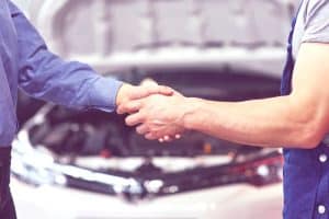 mécanicien automobile et femme cliente concluent un accord sur la réparation de la voiture