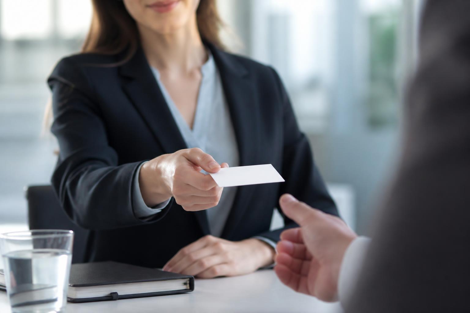 Professionnel tendant une carte de visite lors d'un rendez-vous d'affaires